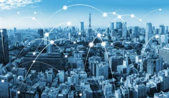 Un horizonte urbano con líneas de red digital y nodos superpuestos, que representan la conectividad de Telcel y el intercambio continuo de datos entre edificios urbanos.