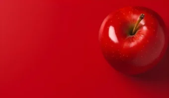 Una sola manzana roja con tallo se encuentra sobre un fondo rojo intenso, ubicada en la esquina superior derecha de la imagen.