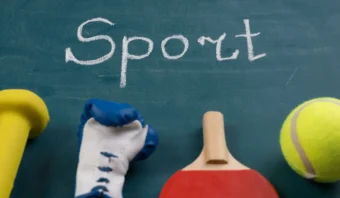 Una pizarra con la palabra "Deporte" escrita en ella y varios equipos deportivos, entre ellos una mancuerna, un guante de boxeo, una paleta de tenis de mesa y una pelota de tenis, dispuestos en la parte inferior, resalta elementos centrales para el marketing deportivo.