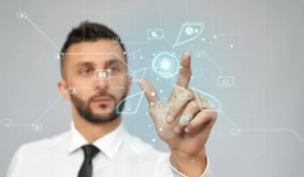Un hombre con camisa blanca y corbata interactÃºa con una interfaz digital transparente, tocando Ã­conos virtuales mientras explora quÃ© nos depara el 2025 en el cambiante mundo de la tecnologÃ­a.
