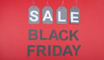 Las etiquetas de oferta de color gris cuelgan sobre un texto en negrita que dice "Viernes Negro" sobre un fondo rojo, capturando la emociÃ³n de las ofertas de El Buen Fin.