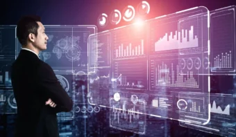 Un hombre con traje observa múltiples pantallas de datos virtuales que muestran gráficos, cuadros y análisis sobre un fondo de paisaje urbano, considerando cuidadosamente cómo elegir un KPI clave para su negocio.