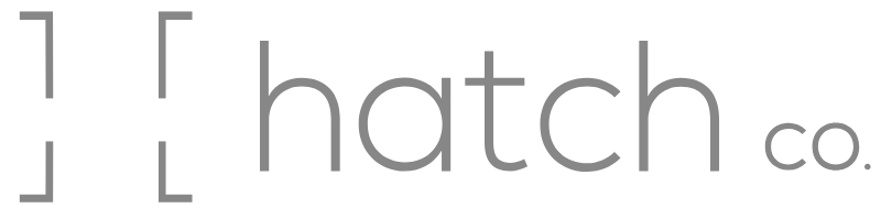 Logotipo con corchetes grises y el texto "hatch co." en letras minúsculas.