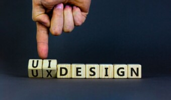 Una persona señala un bloque de madera que dice ux design.