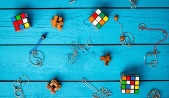 Una variedad de juguetes y rompecabezas dispuestos creativamente sobre un fondo azul para marketing experiencias.