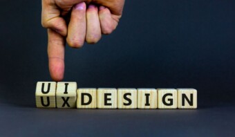 Una persona señala un bloque de madera que dice Diseño de interfaz de usuario.