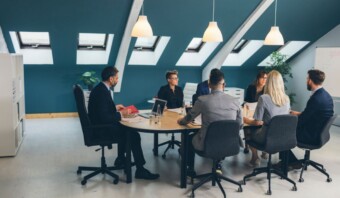 Un grupo de empresarios sentados alrededor de una mesa en una oficina de la AsociaciÃ³n mexicana.