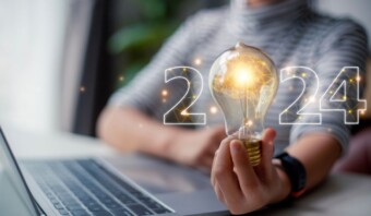 Una mujer sosteniendo una bombilla con la palabra 2240.