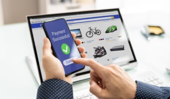 Un hombre utiliza aplicaciones móviles para comprobar un producto en una computadora portátil.