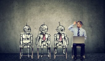 Un hombre sentado frente a un grupo de robots impulsados por la IA.