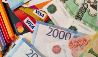 Un montón de billetes y lápices sobre una mesa.