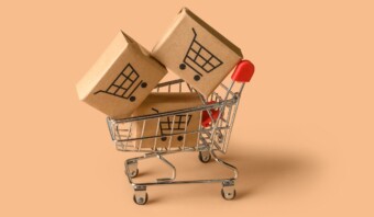 Un carrito de compras de Mercado Libre lleno de cajas sobre un fondo beige.