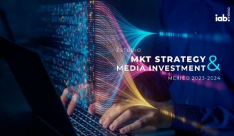 Descripción: Un hombre en un portátil con las palabras estrategia de marketing e inversión en medios.