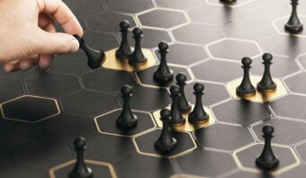 Mano posicionando una pieza de ajedrez en un tablero hexagonal.