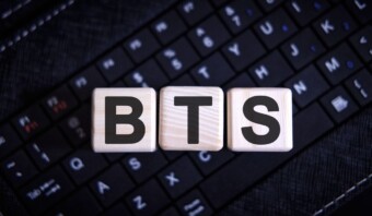 Bloques de madera que deletrean "BTS" en un teclado de computadora.