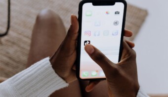 Una persona sostiene un teléfono inteligente y está a punto de abrir la aplicación TikTok, que destaca en la pantalla entre otras aplicaciones.