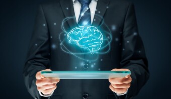 Una persona con traje sostiene una tableta que muestra una imagen holográfica de un cerebro rodeado de elementos digitales, que encarna las complejidades de la comunicación política.