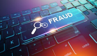 Un teclado con la tecla marcada “FRAUDE” resaltada, con íconos de una lupa y una tecla, da una pista de los peligros acechantes del fraude digital.