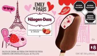 El envase de la barra de helado de fresas y crema de Häagen-Dazs presenta ilustraciones de la Torre Eiffel, una silla y una mesa con el logotipo de "Emily en París". Incluye advertencias nutricionales e imagen del producto. Texto en español.