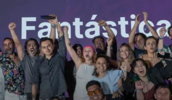 Un grupo de personas celebrando con los puños en alto frente a una pantalla donde se muestran las palabras "Fantástica" y "Agencia Eficaz del Año".