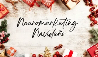 Adornos festivos navideños rodean el texto “Neuromarketing Navideño” sobre un fondo de madera.