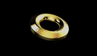 Un anillo de oro con el centro abierto, que presenta un pequeño logotipo grabado, sobre un fondo negro.