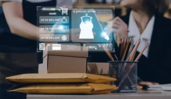 Una persona compra en línea utilizando una interfaz digital que muestra ofertas especiales y descuentos, con paquetes de cartón y papelería en el escritorio.