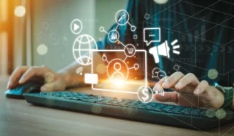 Persona escribiendo en un teclado con íconos digitales de comunicación, finanzas y conectividad flotando sobre la pantalla de una computadora portátil.