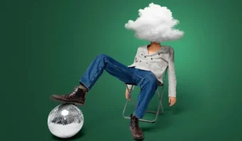 Una persona se sienta en una silla con una nube cubriéndole la cabeza, vistiendo jeans y botas, al lado de una bola de discoteca sobre un fondo verde, una imagen que captura el poder surrealista del marketing emocional.
