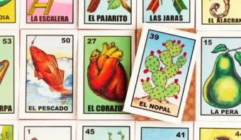 Se exhiben cartones de lotería, con El Pescado, El Corazón, El Nopal, La Pera y otras imágenes clásicas del bingo mexicano; La tarjeta El Nopal está colocada en ángulo, mostrando creatividad a la mexicana.