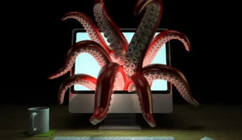 Un monitor de computadora muestra grandes tentáculos de pulpo rojo que emergen de la pantalla, como si salieran de la Deep Web, con un teclado, un mouse y una taza de café en el escritorio frente a él.
