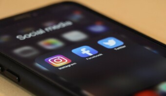 La pantalla de un teléfono inteligente muestra una carpeta denominada “Redes sociales”, que muestra los íconos de las aplicaciones de Instagram, Facebook y Twitter, plataformas esenciales para conectar las comunidades en línea.