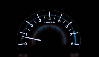 Un indicador de tacómetro, que suele aparecer en campañas automotrices, muestra la velocidad del motor en miles de revoluciones por minuto, con la aguja apuntando ligeramente por encima de 1, lo que indica un poco más de 1.000 RPM.