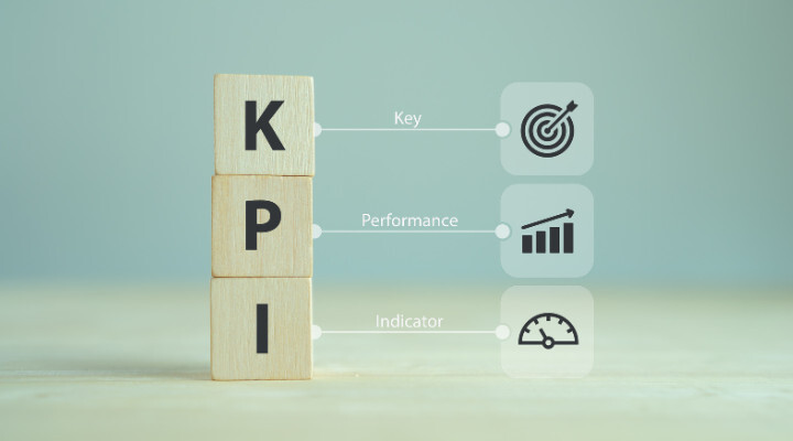 Tres bloques de madera etiquetados como K, P e I están apilados verticalmente, con íconos para Clave, Rendimiento e Indicador junto a cada letra, perfectos para ilustrar cómo elegir un KPI de manera efectiva.