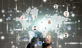 Un hombre interactúa con una interfaz digital que muestra un mapa del mundo conectado por íconos de personas y símbolos de Wi-Fi, representando la comunicación y la creación de redes globales a través de canales digitales.
