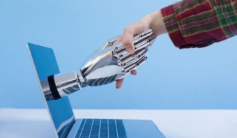 Una mano robótica alcanza una computadora portátil utilizando tecnología de inteligencia artificial o IA.