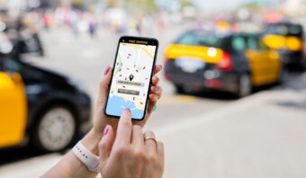 Una mujer usando una aplicación de taxi en su teléfono.