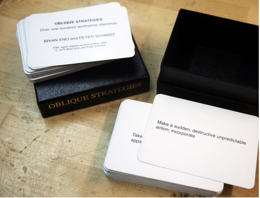 Un juego de cartas con una caja, que demuestra pensamiento estratégico, sentado sobre una mesa.