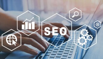 Una persona escribiendo en una computadora portátil con íconos de SEO a su alrededor.