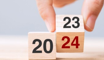 Las razones por las que una mano sostiene un bloque de madera con los números 20 y 24 podrían incluir fines educativos, práctica de matemáticas o aprendizaje de la suma.