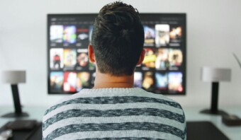 Un hombre sentado frente a un CTV viendo películas.