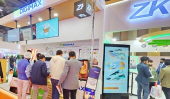 Un grupo de personas paradas frente a un stand que exhibe tecnología de inteligencia artificial.