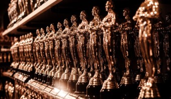 Una fila de estatuas de los Oscar en un estante.