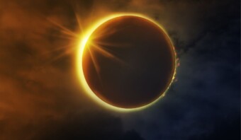 Un eclipse solar con un efecto de anillo de diamantes brillante contra un cielo oscuro y nublado, perfecto para marketing de eventos.