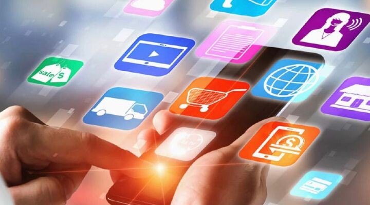 Una persona usa un teléfono inteligente con varios íconos de aplicaciones relacionadas con compras, comunicación, medios y negocios (que ilustran una estrategia de medios moderna) flotando sobre el dispositivo.