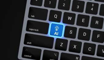 Primer plano de un teclado que muestra una tecla azul única "AI" con un ícono de robot, denominado "GenIA", que reemplaza la posición habitual de la tecla "Intro".