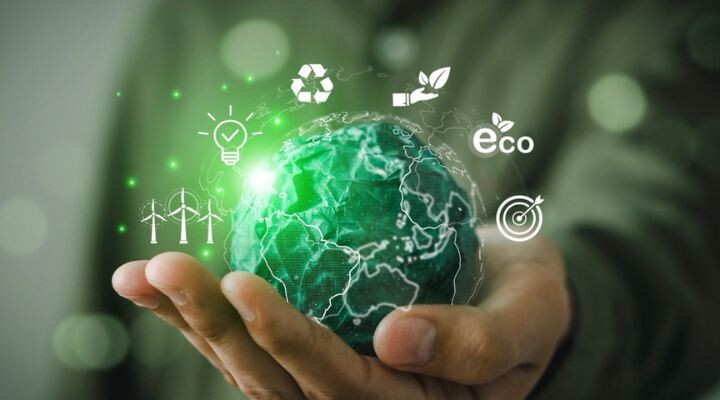 Una mano sostiene un globo digital con íconos ecológicos encima, incluidos el reciclaje, una planta, una bombilla, el texto "eco", turbinas eólicas y un objetivo, que simbolizan la sustentabilidad ambiental y el papel de la publicidad en la promoción de iniciativas ecológicas.