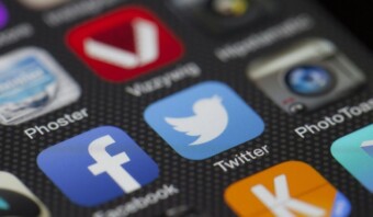 Primer plano de la pantalla de un teléfono inteligente que muestra los íconos de varias aplicaciones, entre ellas Facebook, Twitter, Viddylog y Phoster. Las aplicaciones, cruciales para las relaciones públicas, están organizadas en un sistema de cuadrícula en el dispositivo.