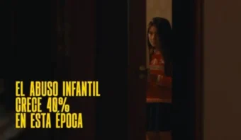 Un niño parcialmente escondido detrás de una puerta. El texto en español dice: "El abuso infantil crece un 40% en esta época".