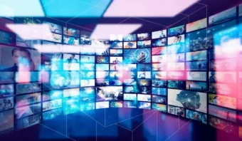 Una pared curva de múltiples pantallas digitales muestra una mezcla ecléctica de medios, mostrando imágenes y gráficos vibrantes en un entorno colorido e iluminado.